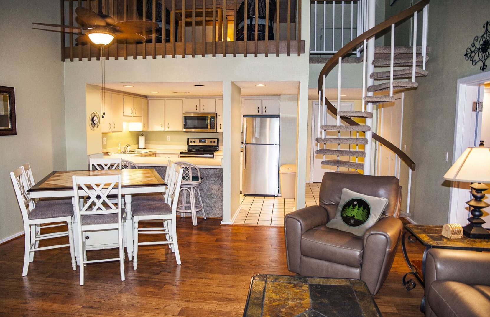 Open living area with spiral staircase to loft